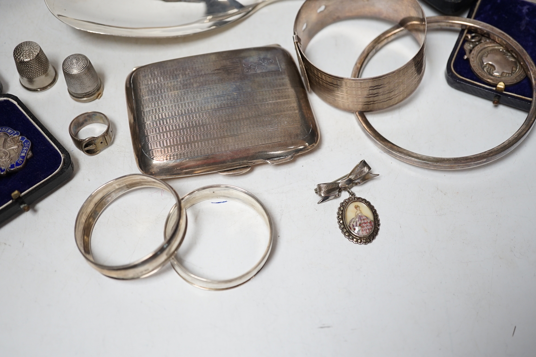 Sundry small silver including a cased preserve spoon, by Albert Edward Jones, a pair of mounted dwarf candlesticks, serving spoon, thimbles, napkin ring etc.